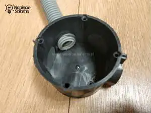 Rura elektroinstalacyjna wprowadzona do puszki poprzez membranę wiatroszczelną. Puszka wiatroszczelna z wprowadzonym peszlem.