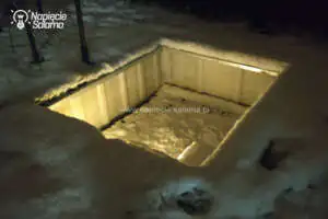 Podświetlony basen zimą, widok nocny z oświetleniem LED w śnieżnym otoczeniu
