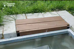 Pokrywa schowka z drewnianych desek zamocowana na kątownikach nad instalacją